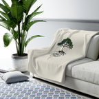Rooted in Christ Sherpa Fleece Blanket draped over a gray sofa in a living room – product mockup