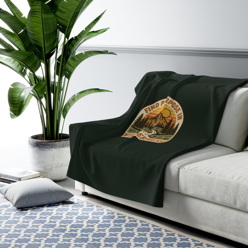 Find Purpose in the Wilderness Sherpa Fleece Blanket draped over a gray sofa in a living room – product mockup