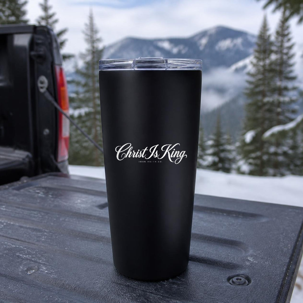 Christ Is King Insulated Tumbler, 20oz in Black on a truck tailgate with snowy mountains behind – digital mockup