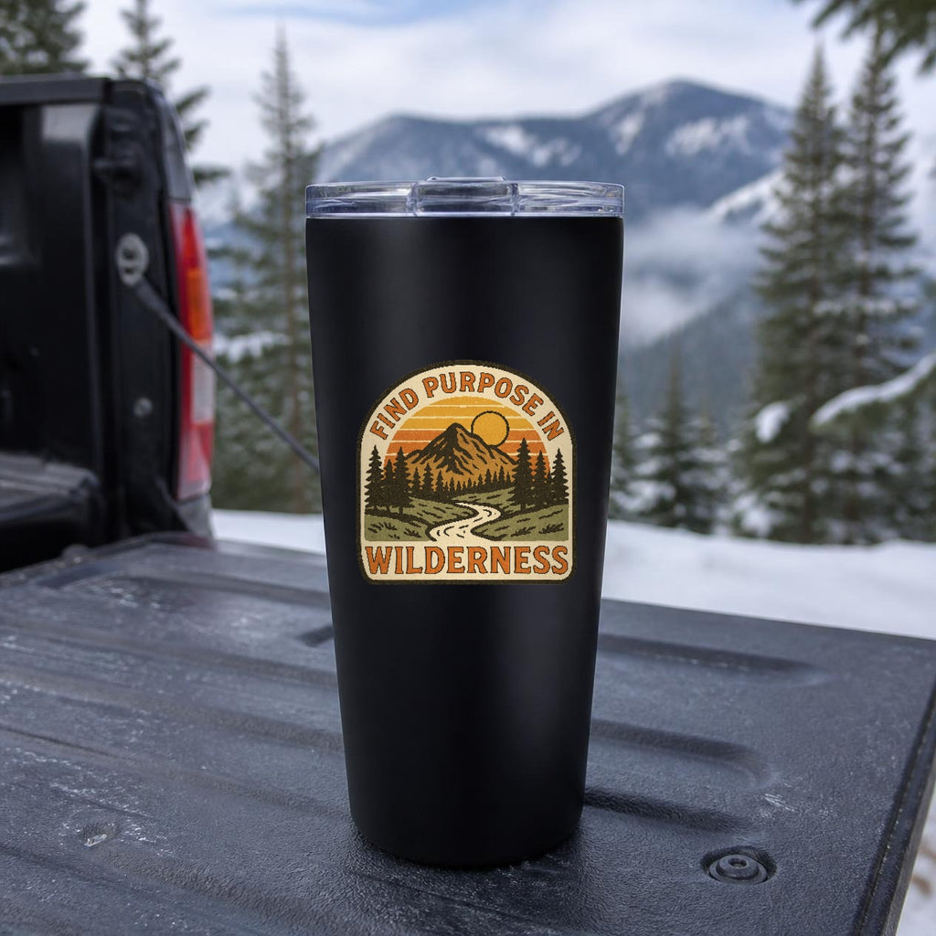Find Purpose in the Wilderness Insulated Tumbler, 20oz in Black on a truck tailgate with snowy mountains behind – digital mockup