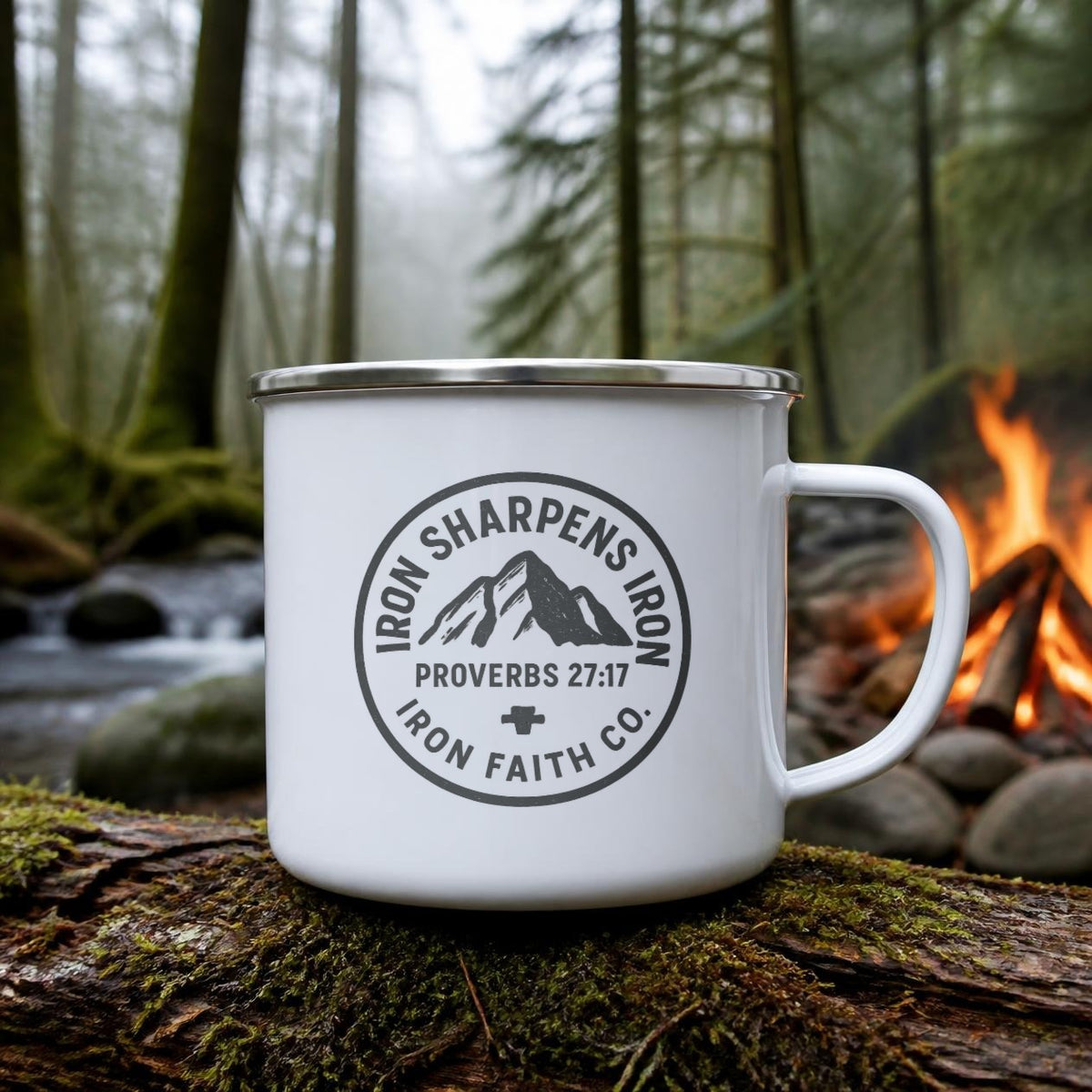Iron Sharpens Iron Enamel Camp Mug (white enamel) on a mossy log beside a campfire – digital mockup