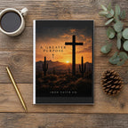The A Greater Purpose Hardcover Journal on a wooden table with coffee, a pen and a pine cone (digitally composited scene image)