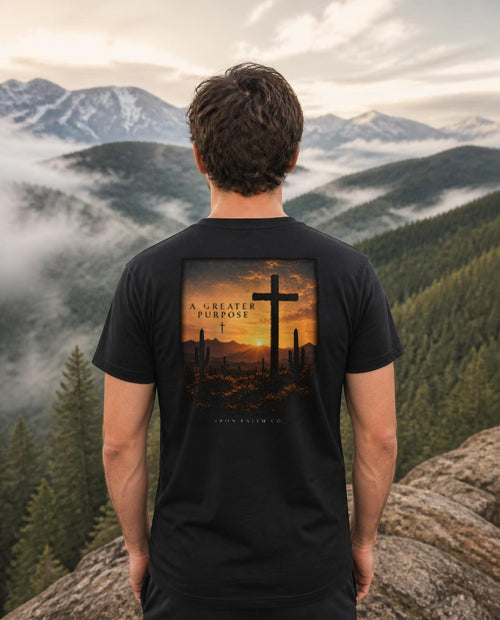 Fictional model wearing the A Greater Purpose Tee – Back Print in Black, back view, Pacific Northwest scene (digitally composited lifestyle image)