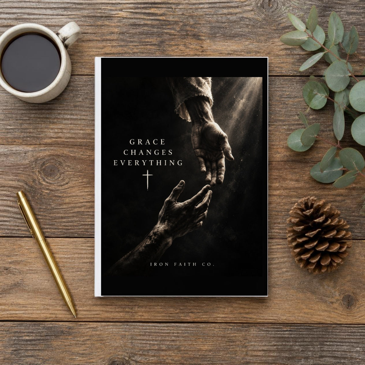 The Grace Changes Everything Hardcover Journal on a wooden table with coffee, a pen and a pine cone (digitally composited scene image)