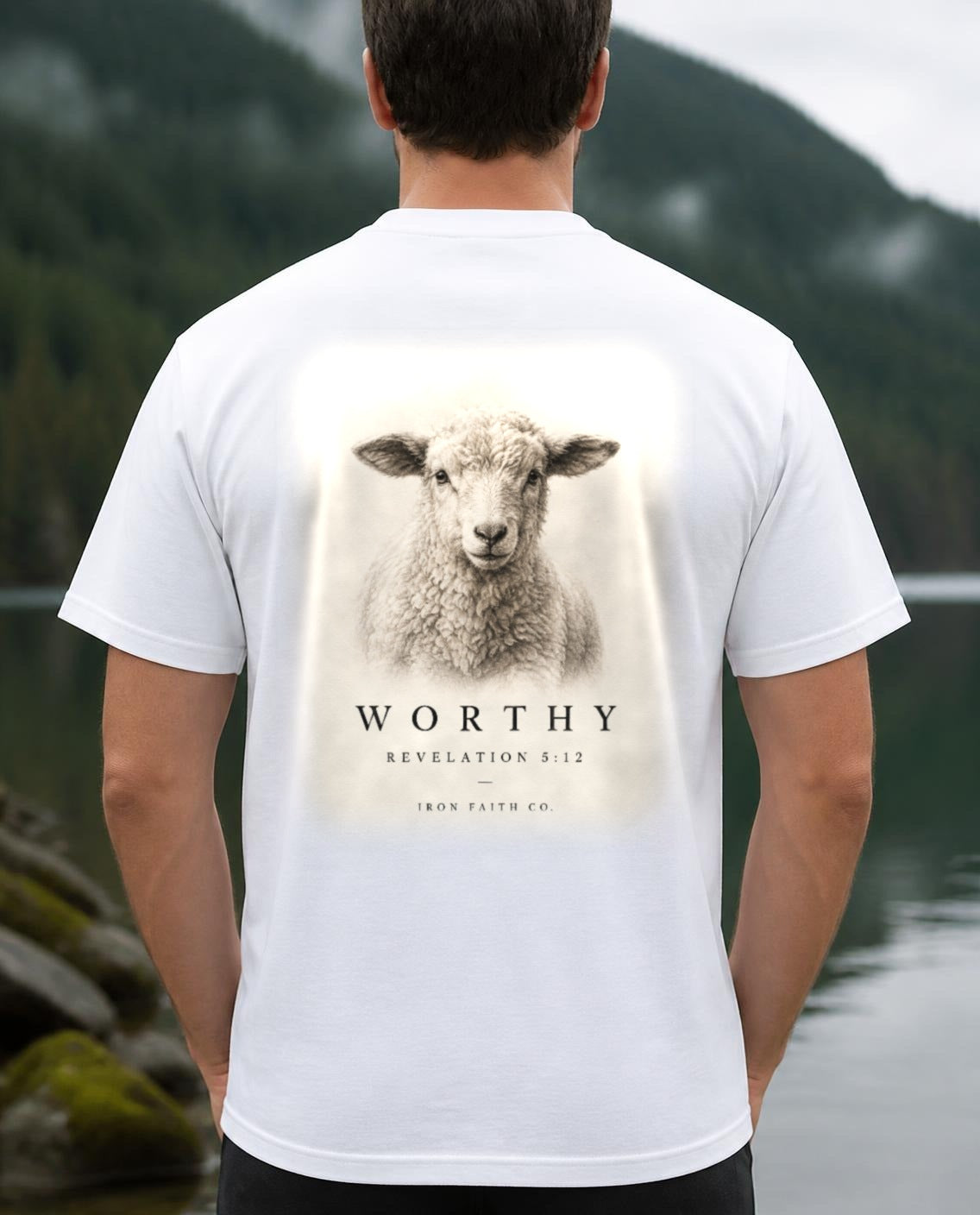 Fictional model wearing the Worthy Revelation 5:12 Tee – Back Print in White, back view, Pacific Northwest scene (digitally composited lifestyle image)