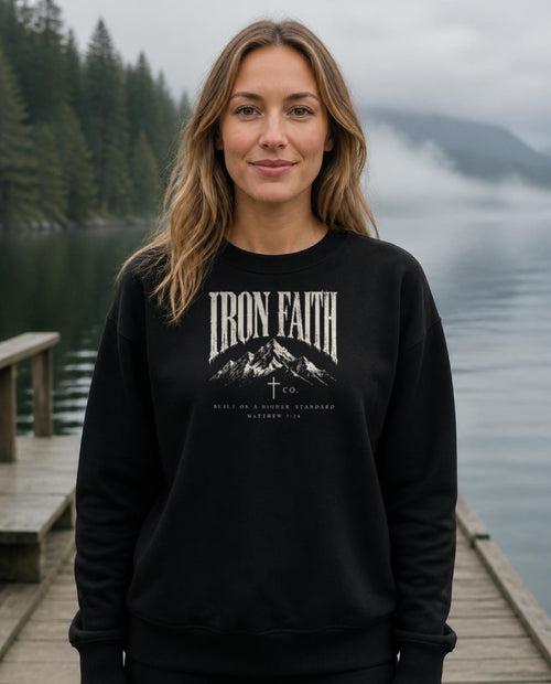 Fictional model wearing the Built on a Higher Standard Crewneck in Black, Pacific Northwest scene (digitally composited lifestyle image)