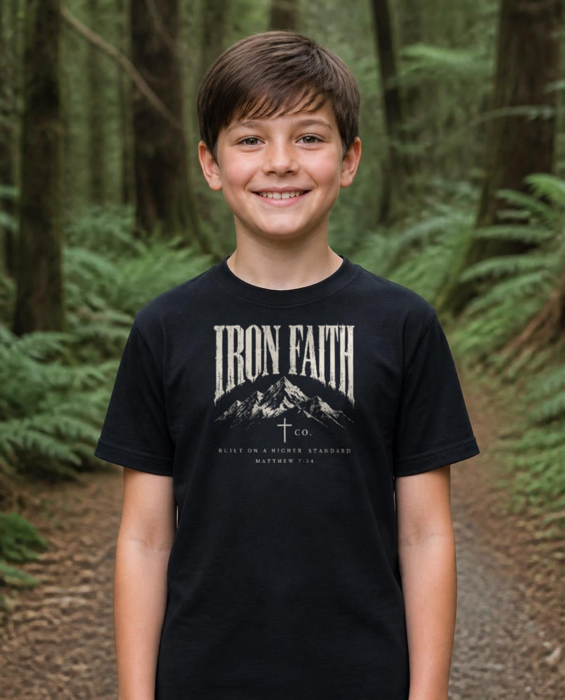 Fictional model wearing the Built on a Higher Standard Youth Tee in Black, Pacific Northwest scene (digitally composited lifestyle image)