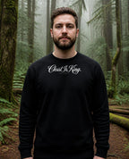 Fictional model wearing the Christ Is King Crewneck in Black, Pacific Northwest scene (digitally composited lifestyle image)