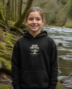 Fictional model wearing the Good Things Come From Obedience Youth Hoodie in Black, Pacific Northwest scene (digitally composited lifestyle image)