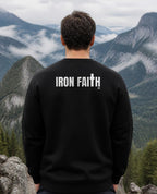 Fictional model wearing the Iron Faith Co. Wordmark Crewneck – Back Print in Black, back view, Pacific Northwest scene (digitally composited lifestyle image)