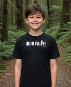 Fictional model wearing the Iron Faith Co. Wordmark Youth Tee in Black, Pacific Northwest scene (digitally composited lifestyle image)