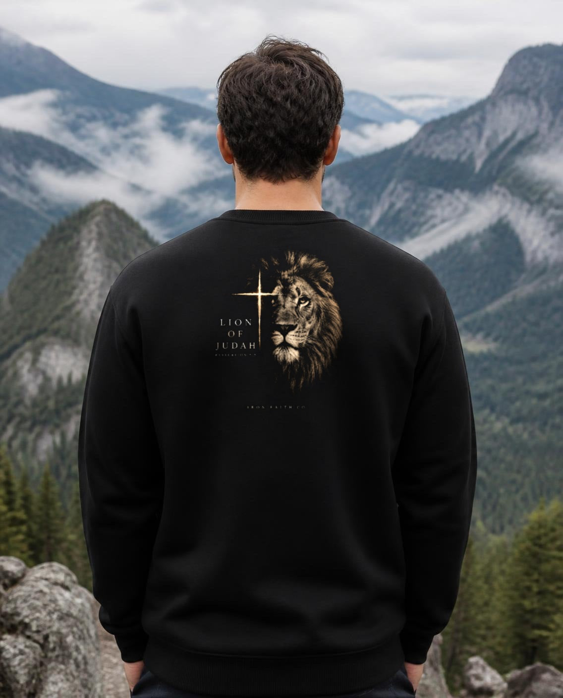 Fictional model wearing the Lion of Judah Crewneck – Back Print in Black, back view, Pacific Northwest scene (digitally composited lifestyle image)