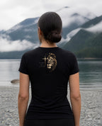Fictional model wearing the Lion of Judah Women's Fitted Tee – Back Print in Black, back view, Pacific Northwest scene (digitally composited lifestyle image)