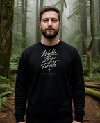 Fictional model wearing the Walk By Faith Crewneck in Black, Pacific Northwest scene (digitally composited lifestyle image)