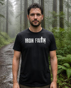 Fictional model wearing the Iron Faith Co. Wordmark Tee in Black, Pacific Northwest forest trail (digitally composited lifestyle image)