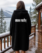 Iron Faith Co. Wordmark Hooded Sherpa Blanket in Black worn by a woman, back view on a snowy porch – digital mockup